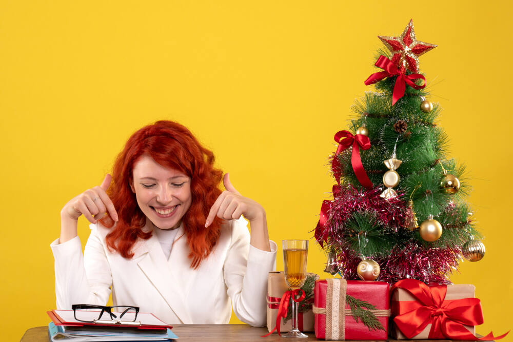 female worker sitting table with presents files yellow